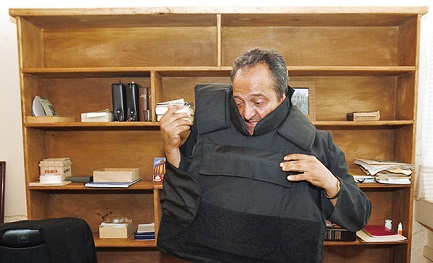 La foto divenuta famosa del sacerdote messicano Gregorio Lopez mentre indossa il giubbotto antiproiettile prima di celebrare la messa